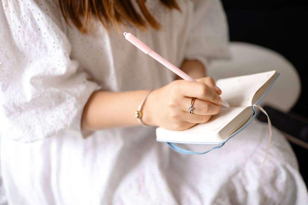 A woman keeps a journal to track her symptoms, helping her identify patterns between hormonal changes and allergy flare-ups.