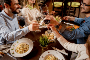Friends enjoying a festive dinner together, celebrating symptom-free after getting allergy testing before the holidays.